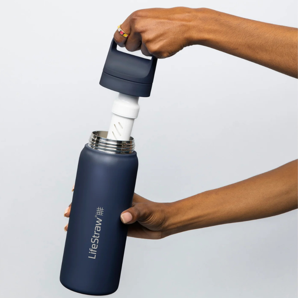 Person holding a LifeStraw water bottle with a filter being inserted on a light gray background. Creative Kids Lab